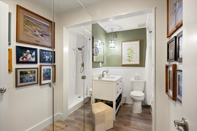 401 E Pearl St Unit 2105, Granbury, TX 76048 - full bath featuring toilet, a stall shower, wood finished floors, vanity, and wainscoting