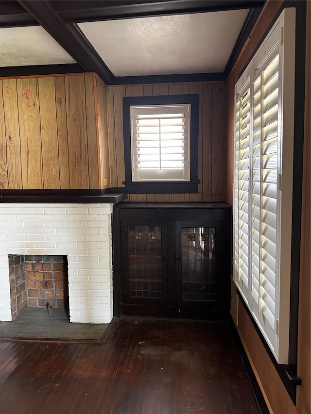 1205 W Arlington Ave, Fort Worth, TX 76110 - unfurnished living room featuring a brick fireplace, dark wood-style flooring, and wooden walls