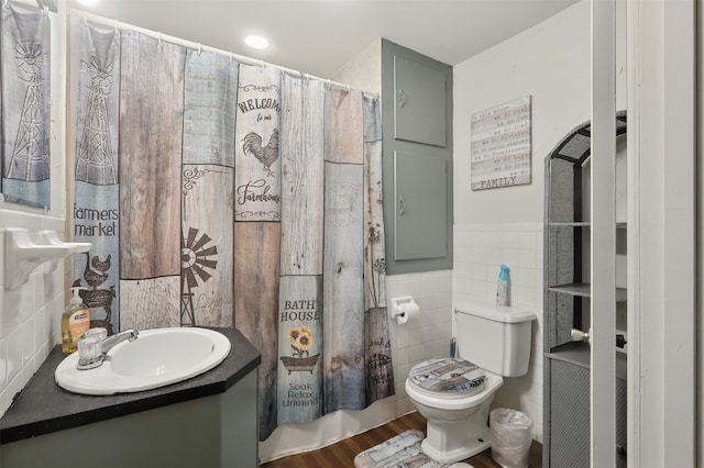 604 S Chestnut St, Winnsboro, TX 75494 - full bathroom with tile walls, toilet, vanity, a wainscoted wall, and wood finished floors