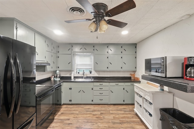 604 S Chestnut St, Winnsboro, TX 75494 - kitchen with black appliances, a sink, under cabinet range hood, dark countertops, and ceiling fan