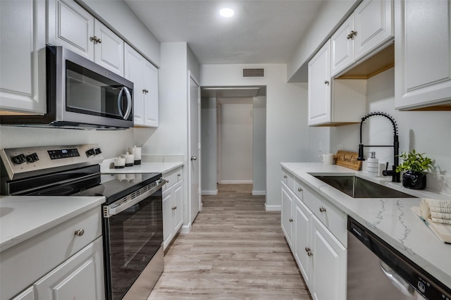 2209 Sheriff Dr, Grand Prairie, TX 75051 - kitchen with stainless steel appliances, a sink, white cabinetry, and recessed lighting