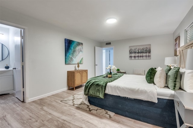2209 Sheriff Dr, Grand Prairie, TX 75051 - bedroom with light wood-style flooring, baseboards, and ensuite bathroom