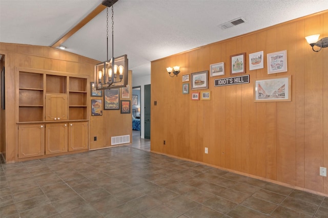 115 Mill Pond Rd, Denton, TX 76209 - unfurnished dining area with a chandelier, built in shelves, and wooden walls