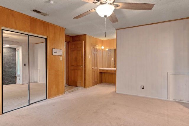 115 Mill Pond Rd, Denton, TX 76209 - unfurnished bedroom with carpet flooring, a textured ceiling, wooden walls, ensuite bath, and a closet