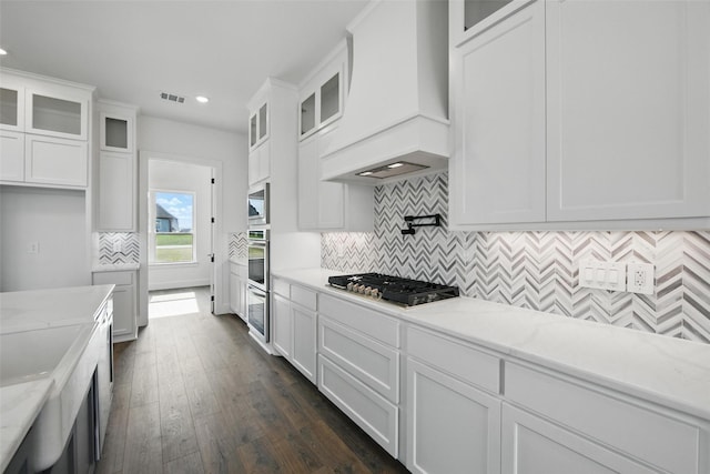 500 Longhorn Dr, Springtown, TX 76082 - kitchen featuring stainless steel appliances, custom exhaust hood, recessed lighting, white cabinetry, and dark wood-style floors