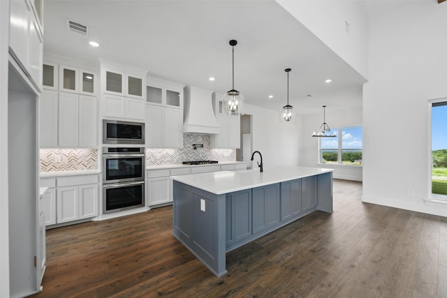 500 Longhorn Dr, Springtown, TX 76082 - kitchen with custom range hood, appliances with stainless steel finishes, backsplash, white cabinetry, and light countertops