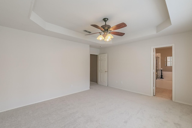8301 Clearbrook Dr, Fort Worth, TX 76123 - unfurnished bedroom featuring a raised ceiling, light carpet, baseboards, ceiling fan, and connected bathroom