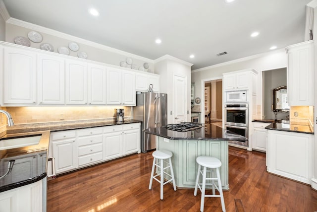 3024 Greenhill Dr, Plano, TX 75093 - kitchen featuring a sink, stainless steel appliances, crown molding, white cabinets, and a kitchen bar