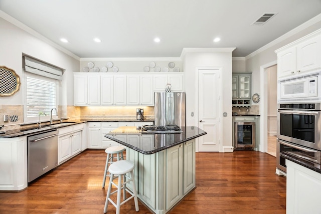 3024 Greenhill Dr, Plano, TX 75093 - kitchen featuring appliances with stainless steel finishes, a sink, wine cooler, dark wood-style flooring, and crown molding