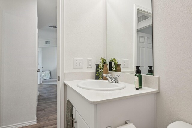 1229 Autumn Mist Ln, Forney, TX 75126 - half bathroom with vanity, wood finished floors, toilet, and a textured wall