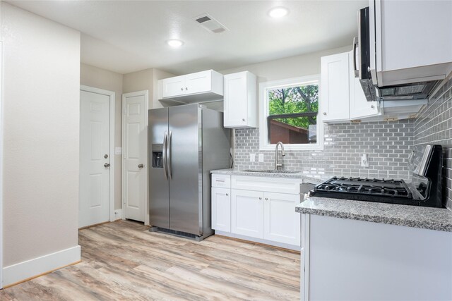 409 Forby Ave, Fort Worth, TX 76103 - kitchen featuring stainless steel fridge, a sink, gas range, backsplash, and light wood finished floors