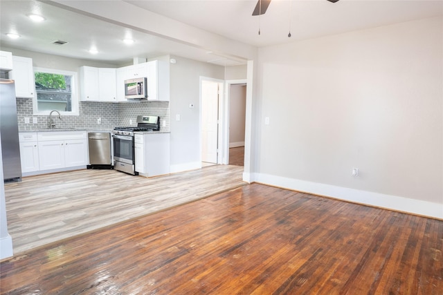 409 Forby Ave, Fort Worth, TX 76103 - kitchen with stainless steel appliances, ceiling fan, tasteful backsplash, light wood-style floors, and baseboards
