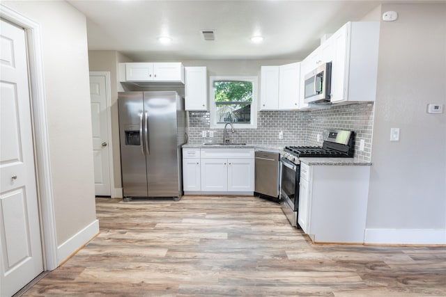 409 Forby Ave, Fort Worth, TX 76103 - kitchen with stainless steel appliances, a sink, white cabinetry, tasteful backsplash, and light stone countertops