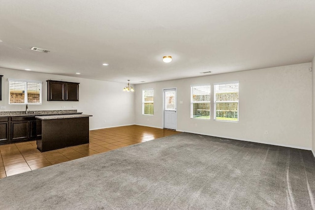 133 Feverbush Dr, Fate, TX 75189 - unfurnished living room featuring tile patterned flooring, a chandelier, recessed lighting, a sink, and baseboards