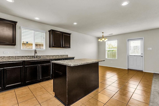 133 Feverbush Dr, Fate, TX 75189 - kitchen with a sink, light tile patterned floors, a chandelier, recessed lighting, and light stone countertops