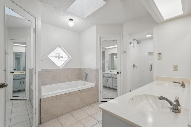 1027 Ridgeview Cir, Carrollton, TX 75007 - bathroom featuring a skylight, tile patterned floors, a stall shower, a garden tub, and vanity