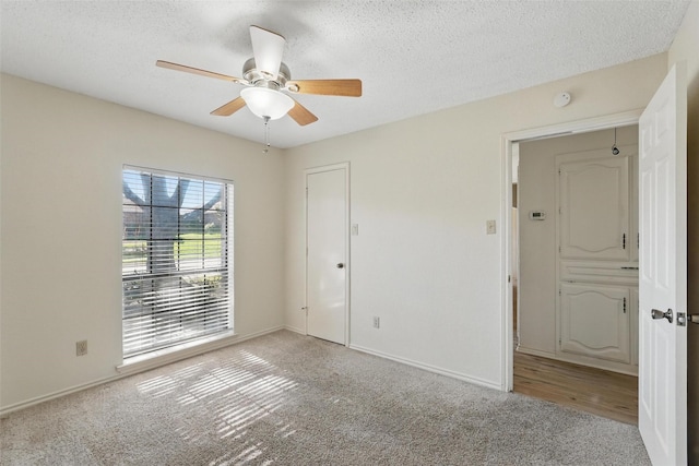 1027 Ridgeview Cir, Carrollton, TX 75007 - unfurnished room with light colored carpet, a ceiling fan, a textured ceiling, and baseboards
