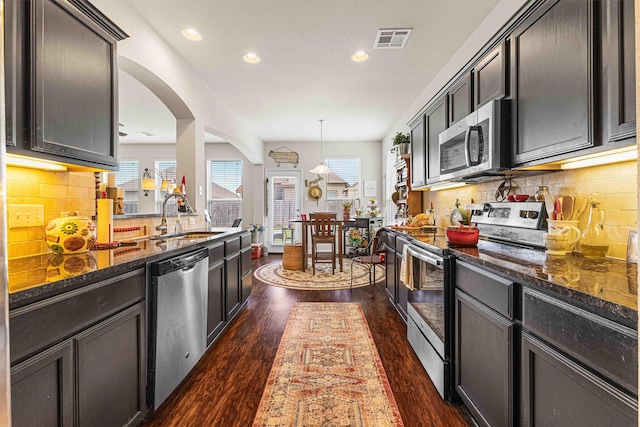 10805 Aurora Dr, Waco, TX 76708 - kitchen with stainless steel appliances, a sink, dark stone counters, recessed lighting, and dark wood-style floors