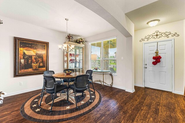 10805 Aurora Dr, Waco, TX 76708 - dining room with dark wood finished floors, a chandelier, baseboards, and arched walkways