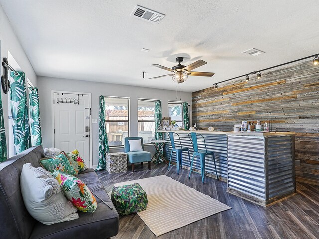 5433 Greenwood Way N, Richland Hills, TX 76180 - living area with wooden walls, ceiling fan, wood finished floors, an accent wall, and a textured ceiling