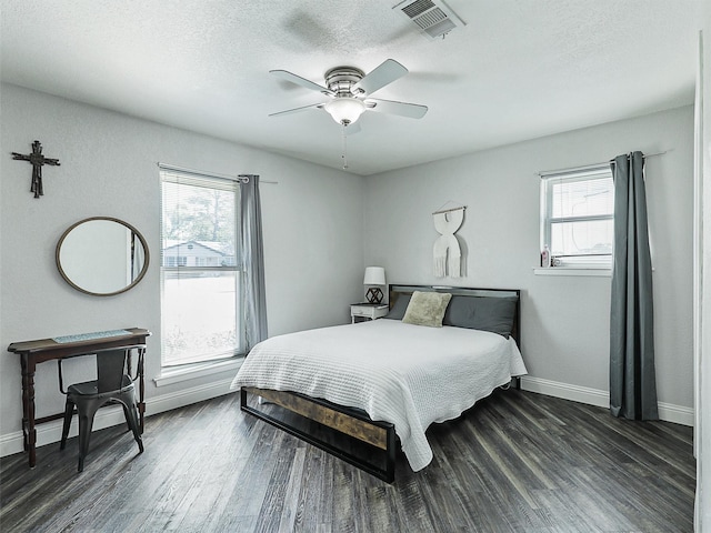 5433 Greenwood Way N, Richland Hills, TX 76180 - bedroom with multiple windows, baseboards, dark wood-type flooring, a textured ceiling, and ceiling fan