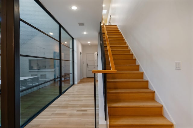 3723 Gilbert Ave, Dallas, TX 75219 - stairs with baseboards, wood finished floors, and recessed lighting
