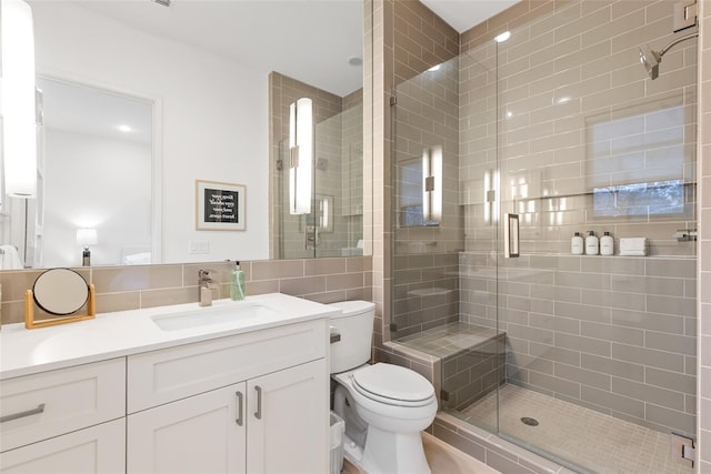 3723 Gilbert Ave, Dallas, TX 75219 - full bathroom featuring vanity, toilet, a shower stall, and tile walls