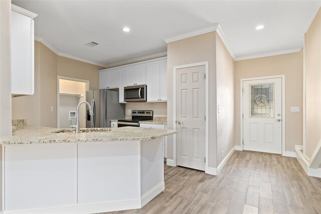 3004 Waterstone Way, Brownwood, TX 76801 - kitchen with appliances with stainless steel finishes, a sink, ornamental molding, light wood-style floors, and white cabinetry