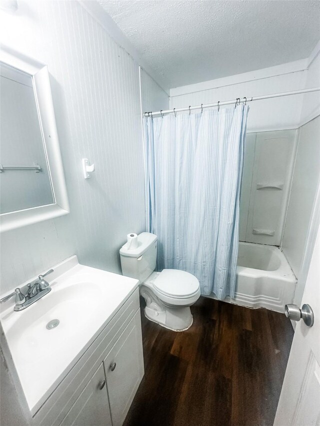 1706 N Ricketts St, Sherman, TX 75092 - bathroom with wood finished floors, toilet, vanity, a textured ceiling, and shower / bath combo with shower curtain