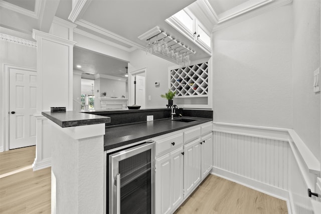 1110 Old Dominion Pl, Mansfield, TX 76063 - indoor wet bar with wine cooler, light wood-style flooring, crown molding, and wainscoting