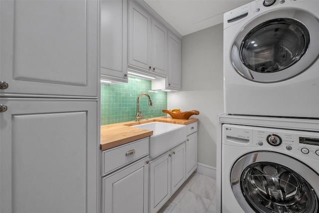 747 Kessler Lake Dr, Dallas, TX 75208 - laundry room with stacked washer / drying machine, cabinet space, light marble finish flooring, and baseboards