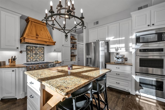 747 Kessler Lake Dr, Dallas, TX 75208 - kitchen with custom exhaust hood, stainless steel appliances, a chandelier, tasteful backsplash, and dark wood-style flooring