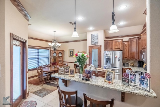 5158 Spring Creek Rd, Abilene, TX 79602 - kitchen with appliances with stainless steel finishes, a breakfast bar, light tile patterned floors, light stone countertops, and ornamental molding