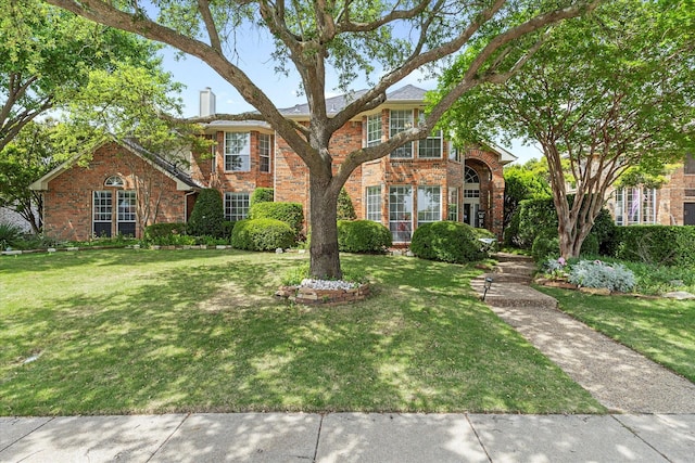 1590 N Hills Dr, Rockwall, TX 75087 - traditional home featuring a front yard, brick siding, and a chimney
