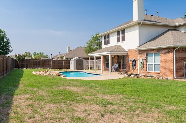 3066 Stoney Hollow Ln, Rockwall, TX 75087 - rear view of property featuring a storage unit, a patio area, a shingled roof, an outdoor structure, and brick siding