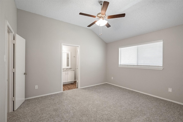 1133 Rosewood Ln, Lancaster, TX 75146 - unfurnished bedroom featuring carpet, lofted ceiling, baseboards, connected bathroom, and a ceiling fan
