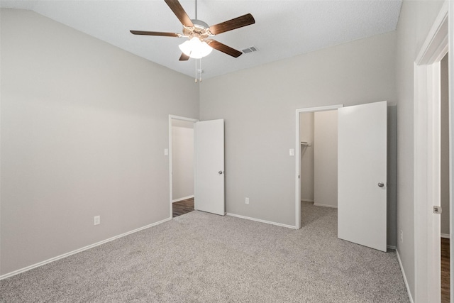 1133 Rosewood Ln, Lancaster, TX 75146 - unfurnished bedroom with a spacious closet, carpet, vaulted ceiling, baseboards, and ceiling fan