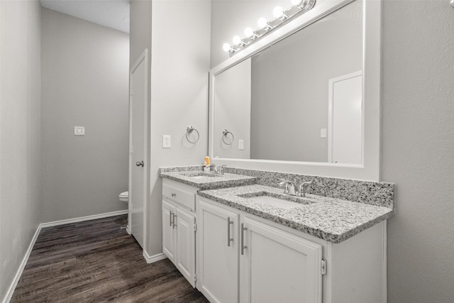 1133 Rosewood Ln, Lancaster, TX 75146 - bathroom with wood finished floors, baseboards, double vanity, and toilet
