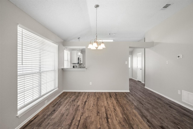 1133 Rosewood Ln, Lancaster, TX 75146 - unfurnished dining area featuring a chandelier, dark wood-style flooring, vaulted ceiling, baseboards, and a textured ceiling