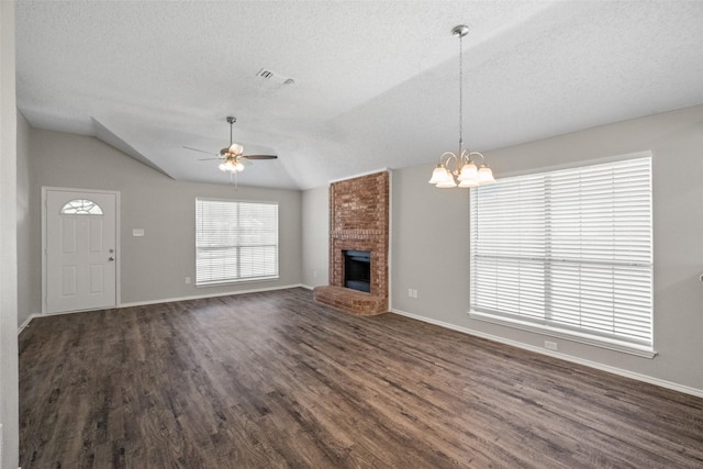 1133 Rosewood Ln, Lancaster, TX 75146 - unfurnished living room with dark wood-style floors, a textured ceiling, a ceiling fan, vaulted ceiling, and a brick fireplace