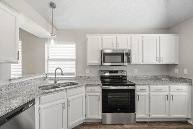 1133 Rosewood Ln, Lancaster, TX 75146 - kitchen with appliances with stainless steel finishes, a sink, white cabinetry, pendant lighting, and a textured ceiling