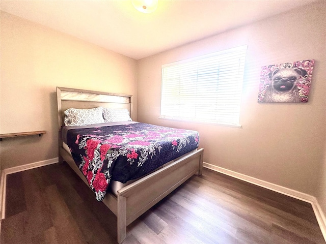bedroom with wood finished floors and baseboards