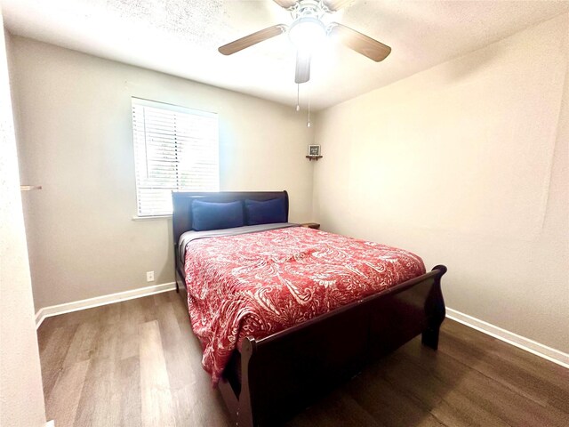 bedroom featuring wood finished floors, baseboards, and ceiling fan