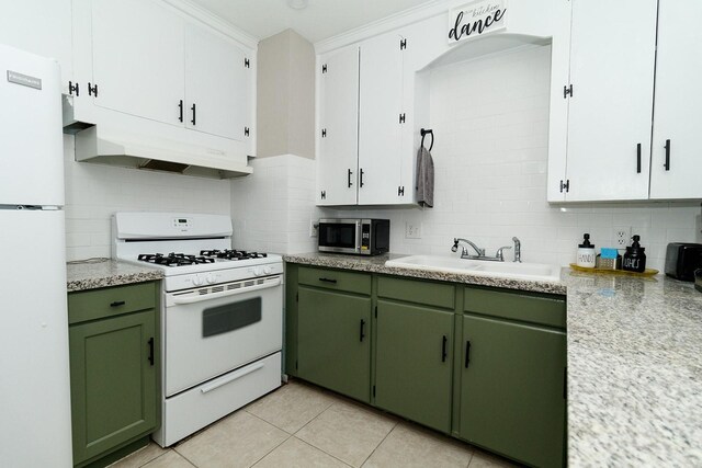 kitchen featuring white appliances, green cabinets, a sink, and backsplash