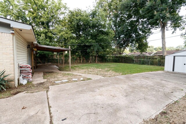 view of yard featuring a shed, a patio, and an outbuilding