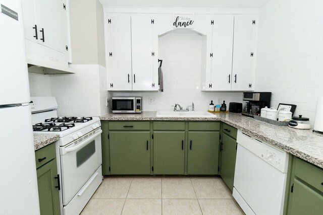 kitchen featuring white appliances, green cabinets, a sink, and light countertops