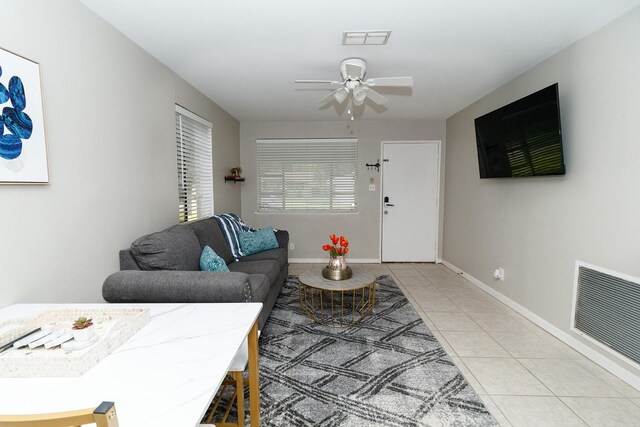 living room featuring light tile patterned flooring, ceiling fan, and baseboards