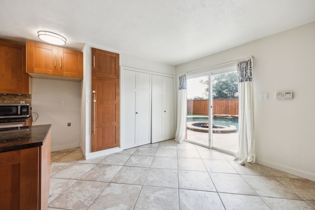 unfurnished dining area featuring baseboards and light tile patterned flooring