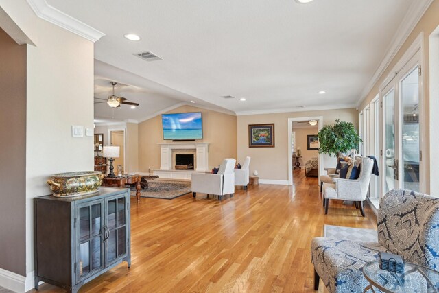 4222 Laren Ln, Dallas, TX 75244 - living area with a ceiling fan, light wood-style flooring, a fireplace with raised hearth, crown molding, and baseboards