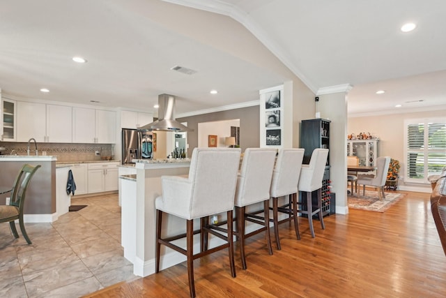 4222 Laren Ln, Dallas, TX 75244 - kitchen featuring island exhaust hood, ornamental molding, white cabinets, stainless steel refrigerator with ice dispenser, and recessed lighting
